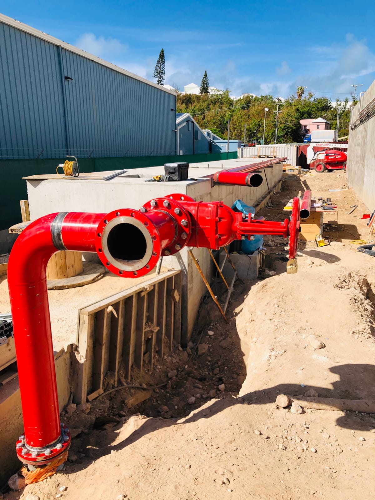 Red fire main turning up out of the ground into a flanged spool and gate valve
