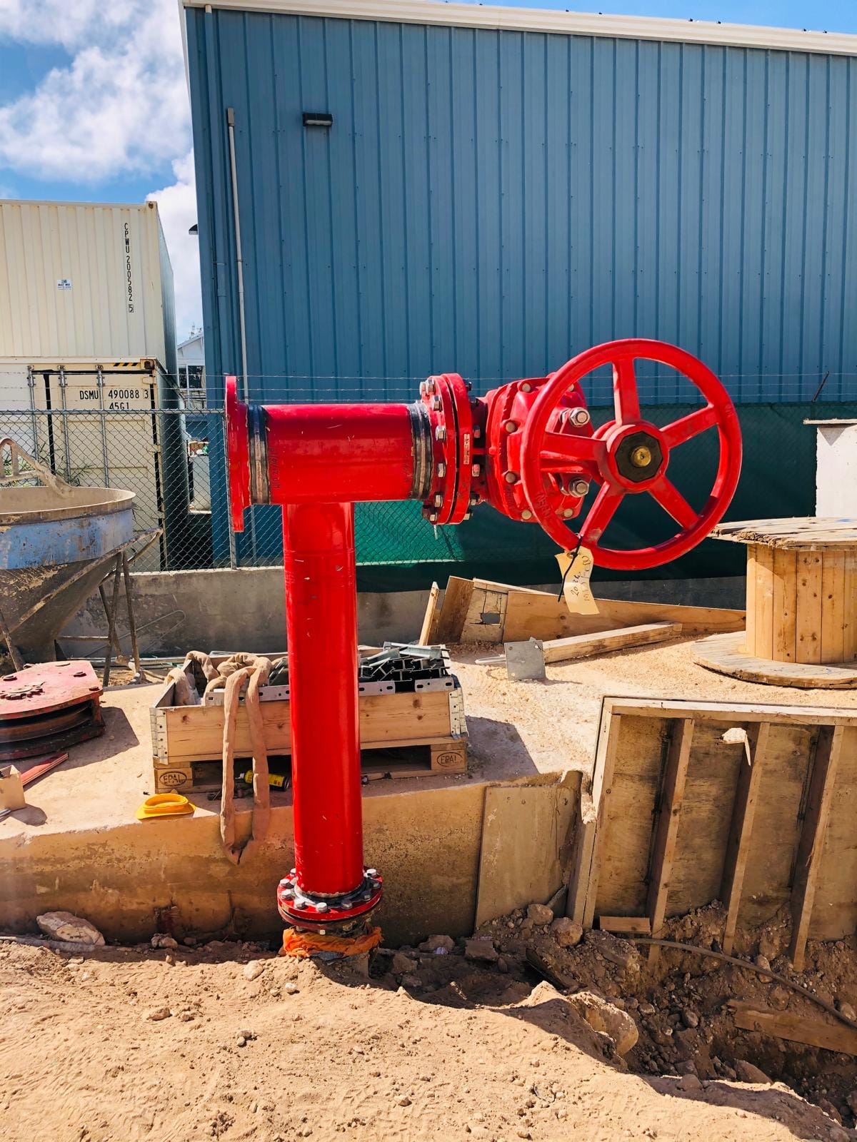 Red external fire hydrant with a gate valve, flanged into a buried main