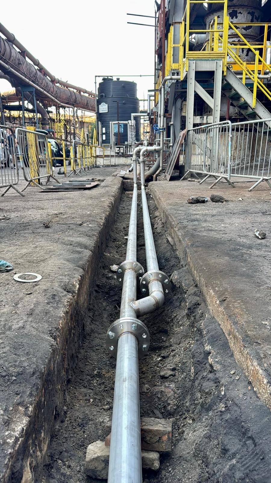 New pipework stepping down into the pit, with barriers along the open edge