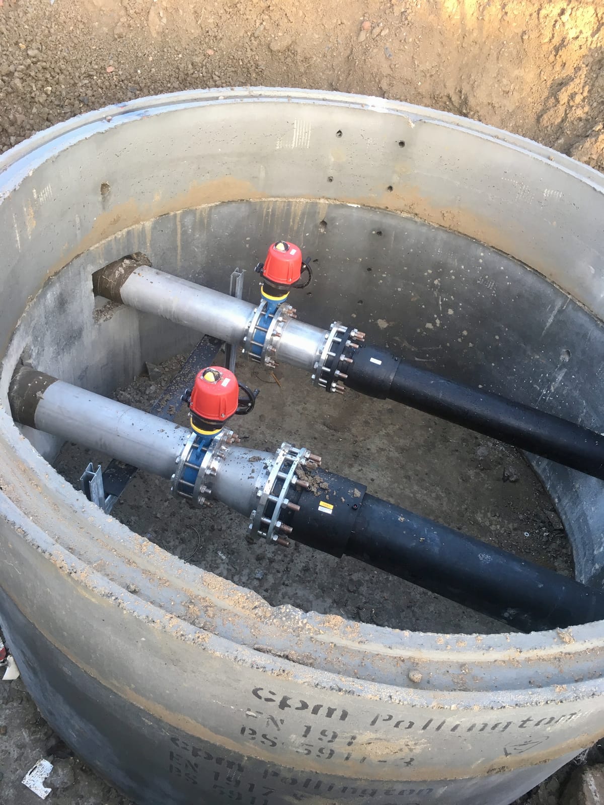 Twin hydrant lines with red capped valves in the chamber