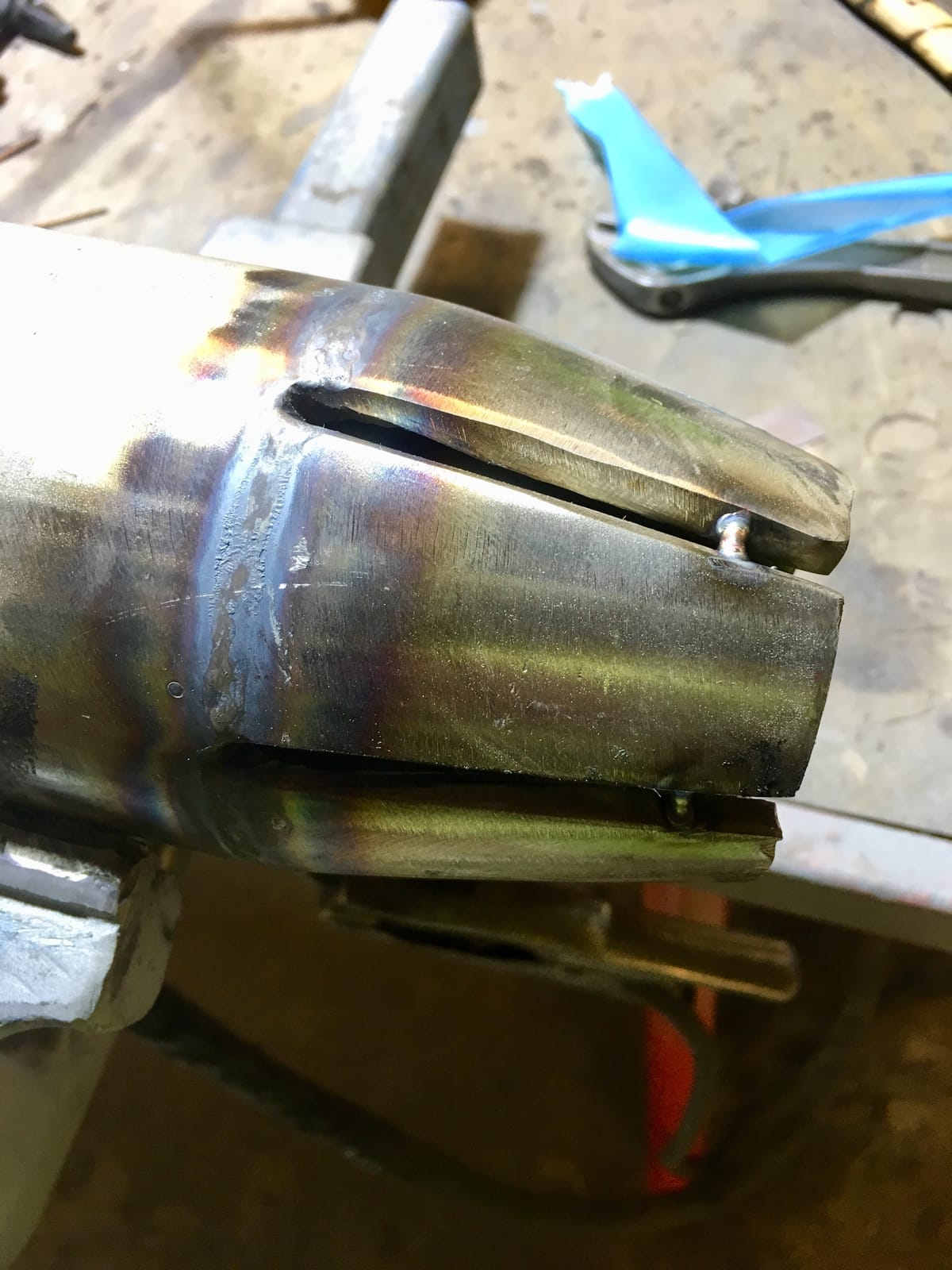 Welded stainless spool with a cut branch opening, clamped on the fabrication bench