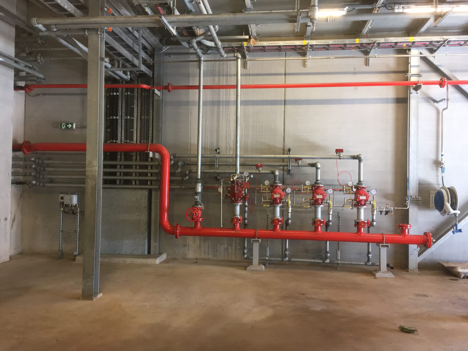 Red deluge valve sets on the fire main in the plant room