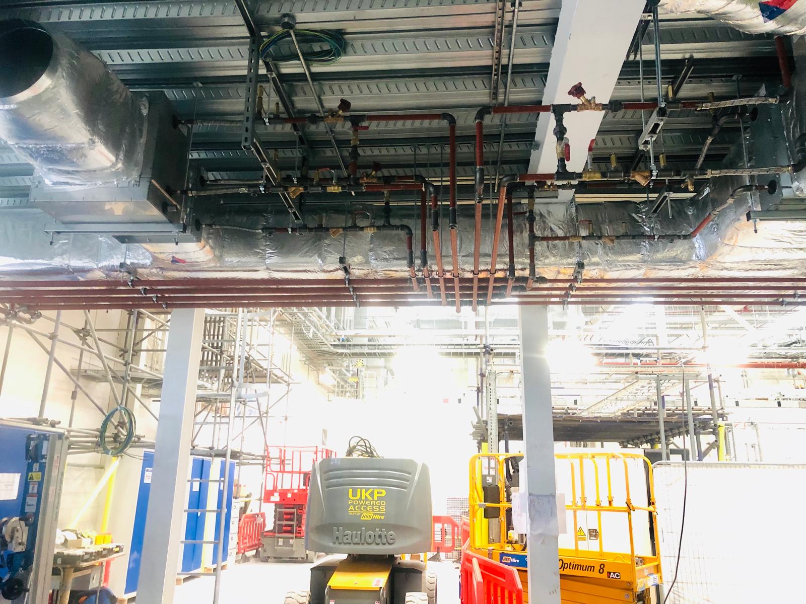 Copper and steel HVAC pipework running overhead in the ceiling void
